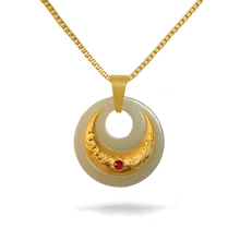 Gold and white pendant necklace with a red gemstone on a white background