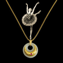 Necklace with a ballerina pendant and gold chain on a black background