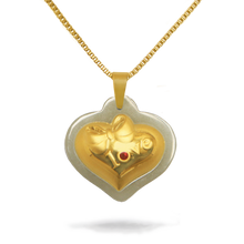 Gold heart-shaped pendant with a red gemstone on a white background