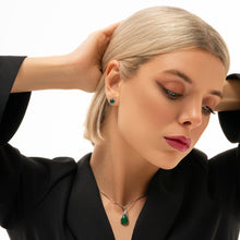 Woman wearing emerald green jewelry against a white background with Marbeline logo.
